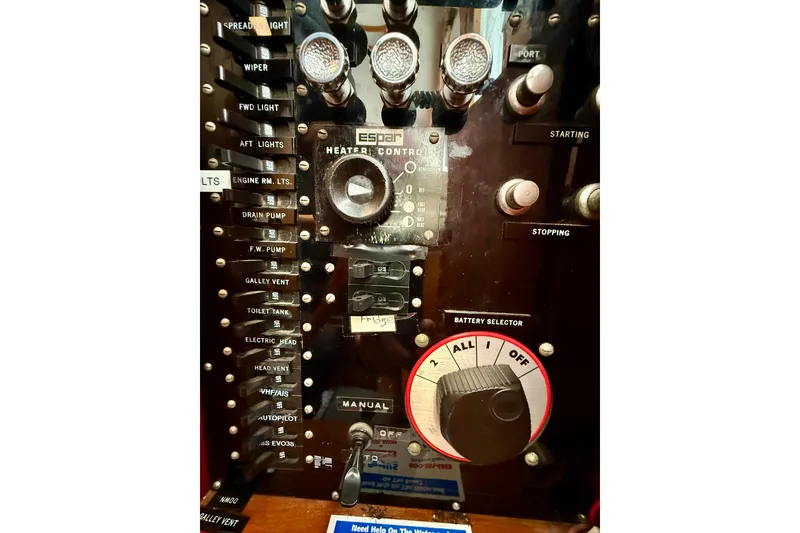 Slide: The Image of Control panel of a 1982 Grand Banks 42 Classic boat with various switches and dials. - 52