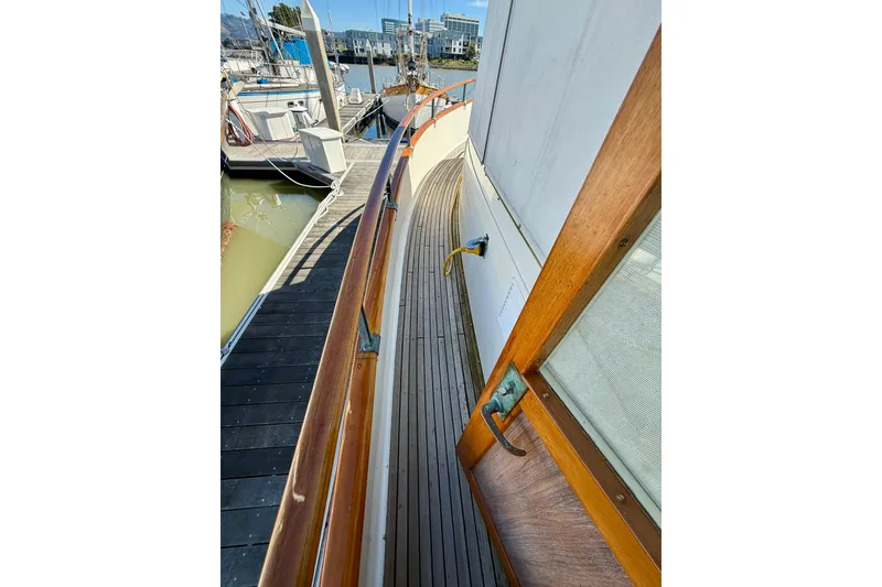 Slide: The Image of 1982 Grand Banks 42 Classic yacht deck with wooden railings and marina view. - 64