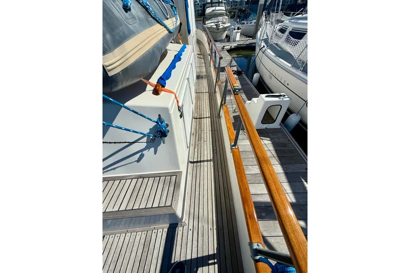 Slide: The Image of 1982 Grand Banks 42 Classic yacht deck with wooden railings and docked boats. - 66