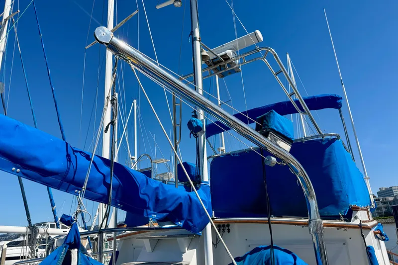 Slide: The Image of 1982 Grand Banks 42 Classic yacht with blue covers and clear sky background. - 67