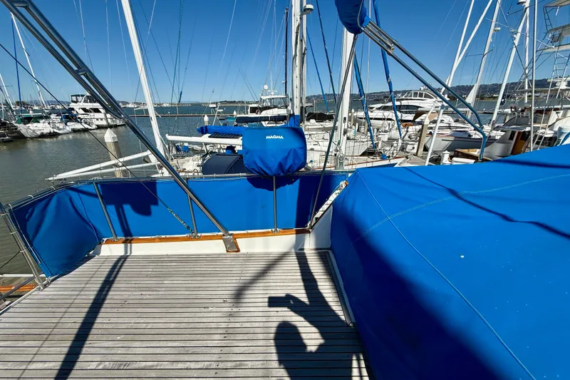 Slide: The Image of 1982 Grand Banks 42 Classic yacht with blue covers docked at a marina. - 71