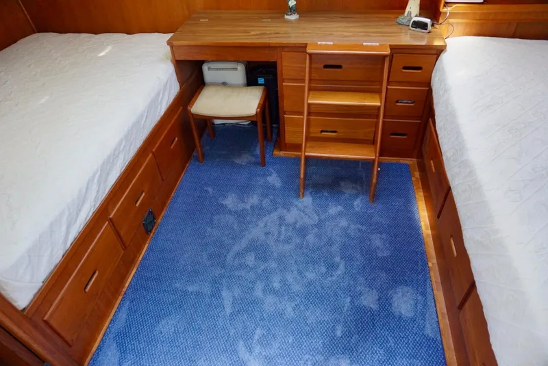 Slide: The Image of 1982 Grand Banks Classic cabin with twin beds, wooden furniture, and blue carpet. - 14