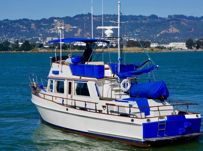 Slide: The Image of 1982 Grand Banks Classic boat on water with blue accents and scenic background. - 3