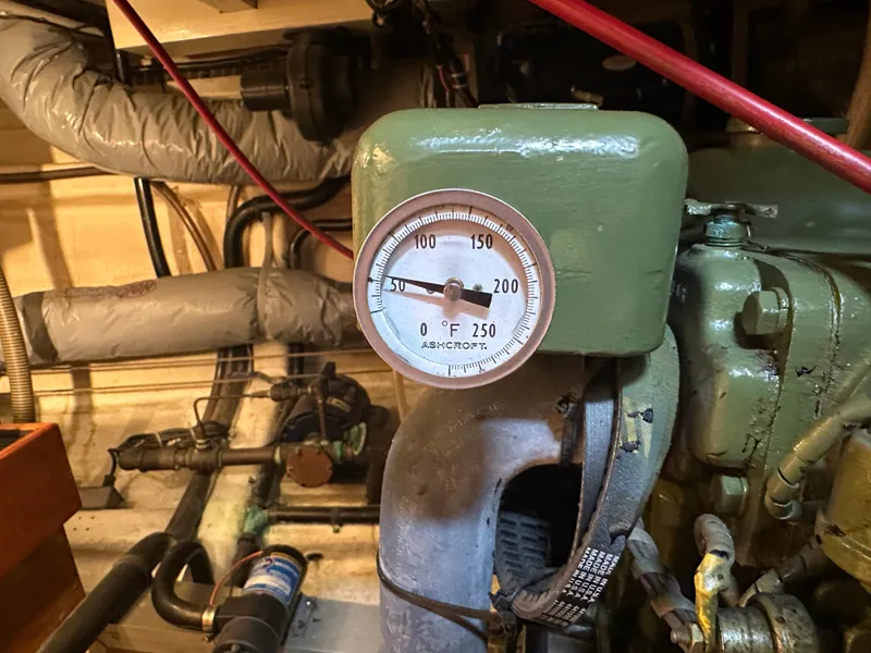 Slide: The Image of Engine room of a 1982 Grand Banks Classic with temperature gauge and pipes. - 34