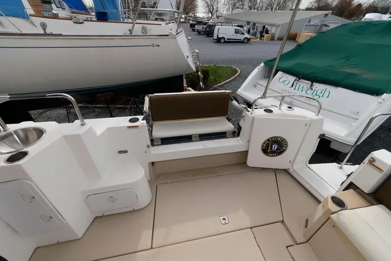 Slide: The Image of 2016 Ranger Tugs R-31S boat deck with seating and storage, docked near other vessels. - 12