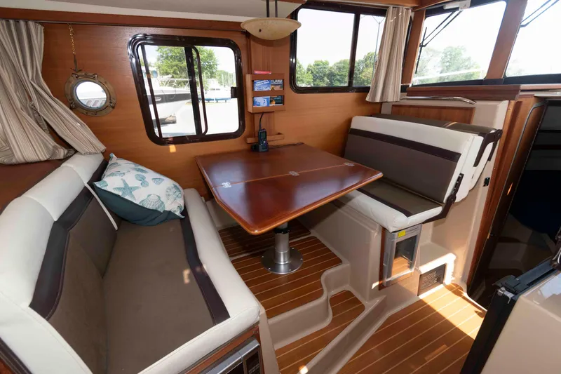 Slide: The Image of 2016 Ranger Tugs R-31S interior with cozy seating and wooden table. - 14