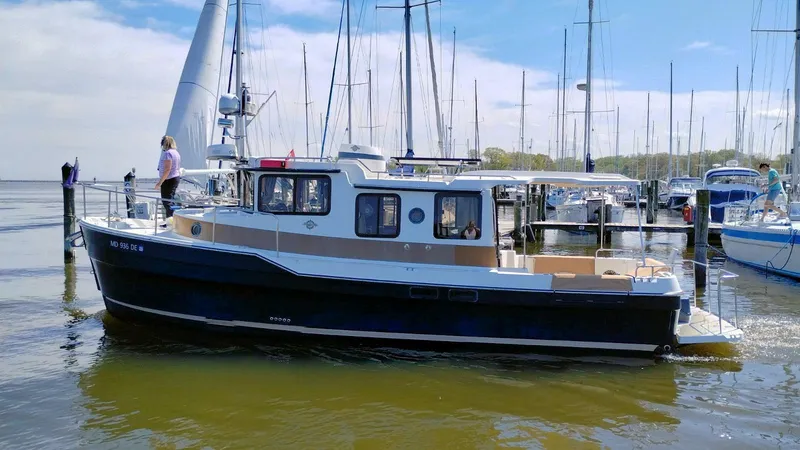 Slide: The Image of 2016 Ranger Tugs R-31S boat docked in a marina with people on board. - 2
