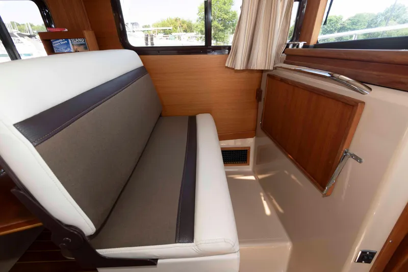 Slide: The Image of 2016 Ranger Tugs R-31S interior with cushioned seating and wooden accents. - 22