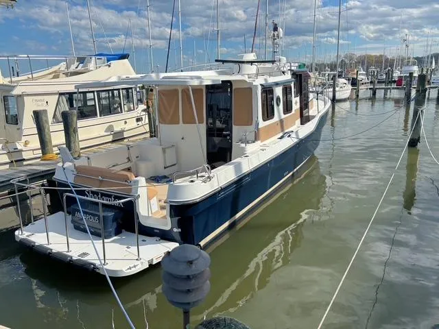 Slide: The Image of 2016 Ranger Tugs R-31S docked at a marina under a partly cloudy sky. - 3