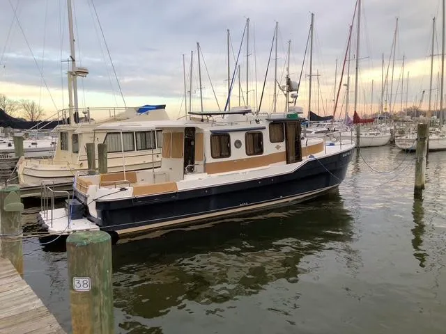 Slide: The Image of 2016 Ranger Tugs R-31S docked at a marina with sailboats in the background. - 4