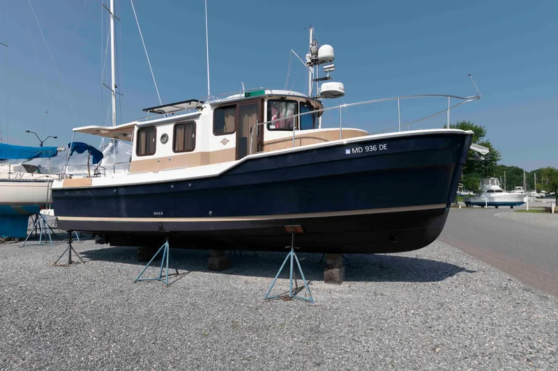 Slide: The Image of 2016 Ranger Tugs R-31S boat on stands, displayed outdoors on gravel. - 6