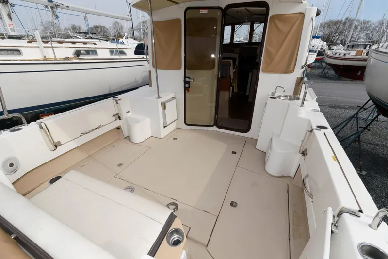 Slide: The Image of 2016 Ranger Tugs R-31S boat deck with spacious seating and open cabin entrance. - 9