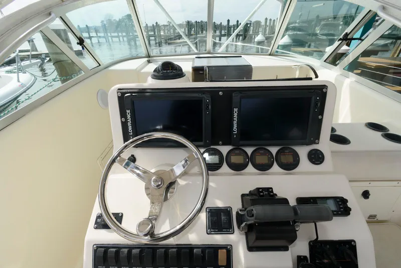 Slide: The Image of 2000 Pursuit 3070 Offshore Center Console helm with steering wheel and navigation displays. - 10