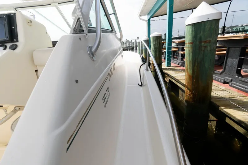 Slide: The Image of 2000 Pursuit 3070 Offshore Center Console docked, showcasing sleek design and sturdy build. - 12