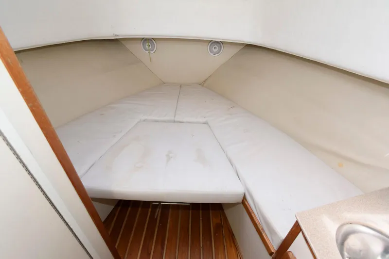 Slide: The Image of Interior cabin of 2000 Pursuit 3070 Offshore Center Console boat with cushioned seating. - 16