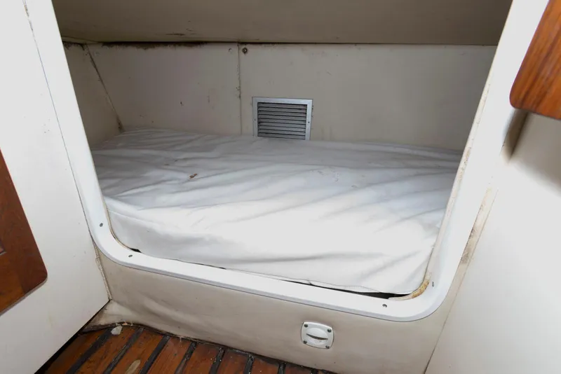 Slide: The Image of 2000 Pursuit 3070 Offshore Center Console cabin interior with a compact sleeping berth. - 18