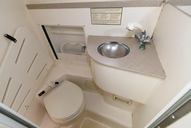 Slide: The Image of 2000 Pursuit 3070 Offshore Center Console boat bathroom with sink and toilet. - 19