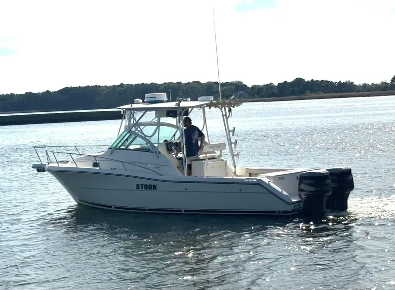 Slide: The Image of 2000 Pursuit 3070 Offshore Center Console boat on calm water, side view. - 3