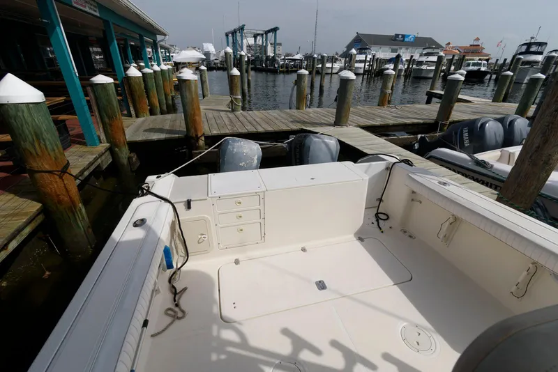 Slide: The Image of 2000 Pursuit 3070 Offshore Center Console docked at a marina, showcasing spacious deck area. - 6