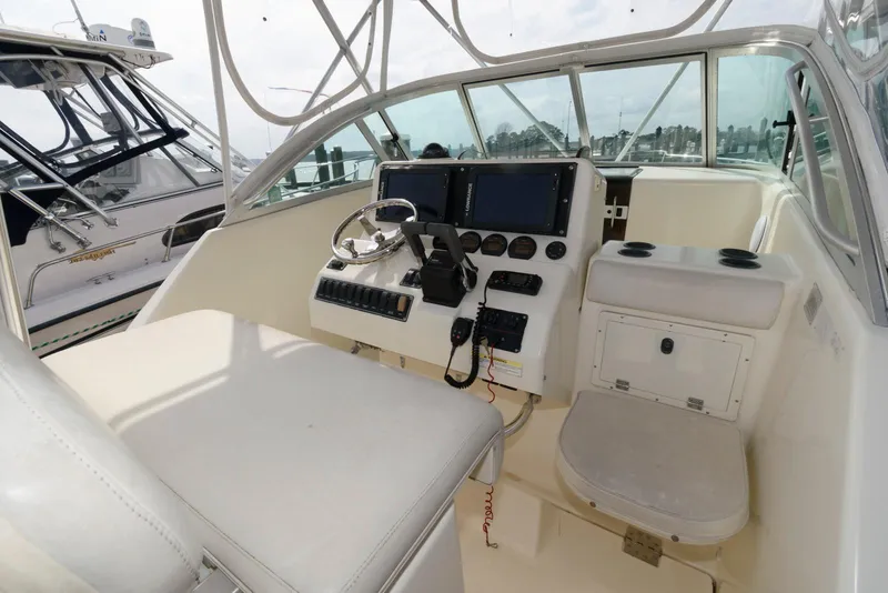Slide: The Image of 2000 Pursuit 3070 Offshore Center Console boat interior with steering wheel and navigation equipment. - 7