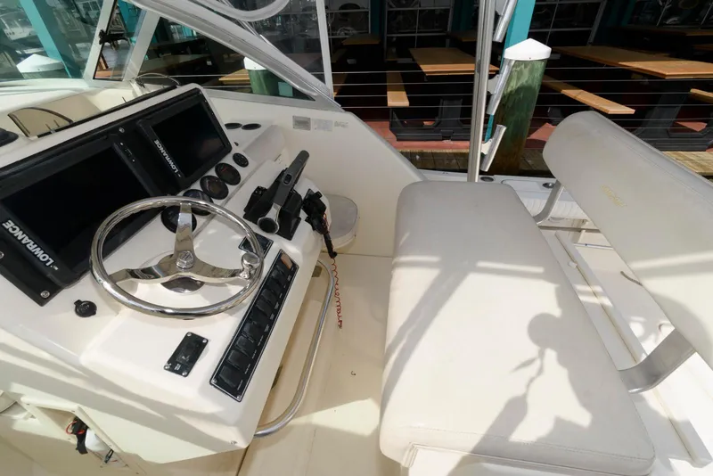 Slide: The Image of 2000 Pursuit 3070 Offshore Center Console boat interior with steering wheel and control panel. - 8