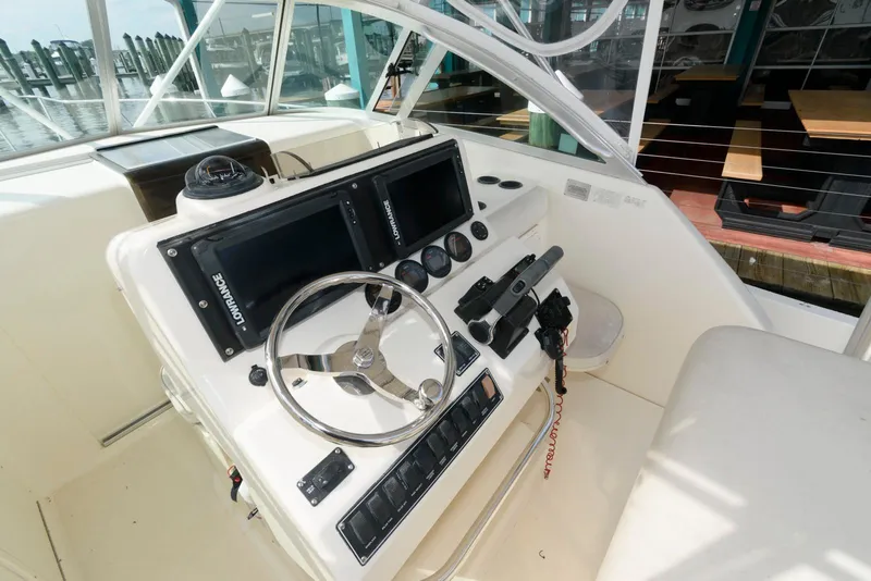 Slide: The Image of 2000 Pursuit 3070 Offshore Center Console helm with dual displays and steering wheel. - 9