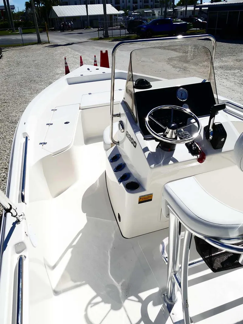 Slide: The Image of 2025 Bulls Bay 2200 boat with sleek console and seating, docked outdoors. - 13
