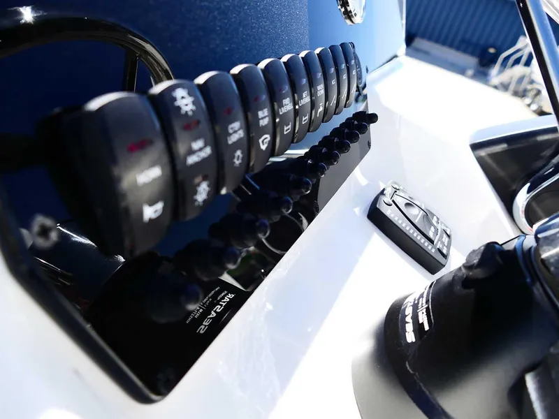 Slide: The Image of Control panel of 2025 Bulls Bay 2200 boat with switches and dials. - 15