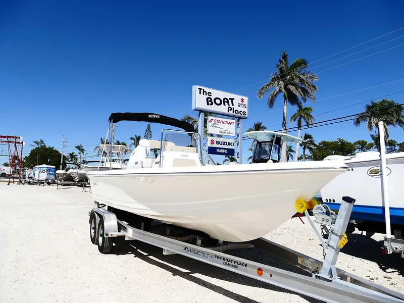 Slide: The Image of 2025 Bulls Bay 2200 boat on trailer at dealership, sunny day, palm trees in background. - 2