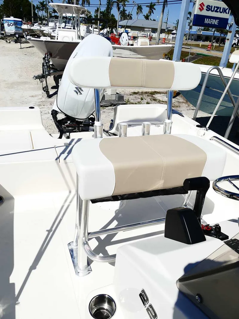 Slide: The Image of 2025 Bulls Bay 2200 boat interior with seating and Suzuki engine in a marina setting. - 32