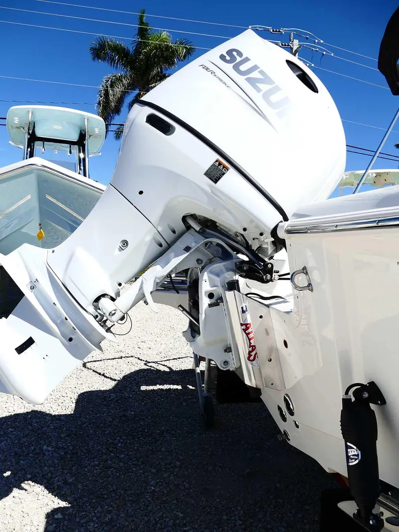 Slide: The Image of 2025 Bulls Bay 2200 boat with Suzuki outboard motor, parked on gravel under clear blue sky. - 8