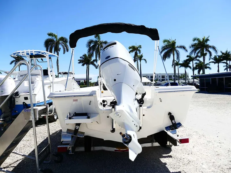 Slide: The Image of 2025 Bulls Bay 2200 boat with outboard motor, parked under clear blue sky and palm trees. - 9