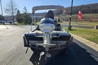 Slide: The Image of 1989 Bomber Crappie Mate boat with outboard motor, parked on a sunny day. - 3