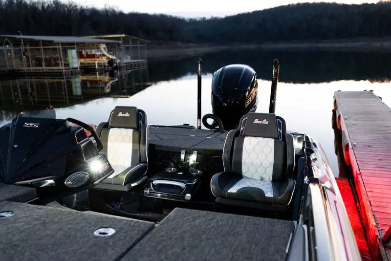 Slide: The Image of 2026 Bass Cat Lynx STS boat interior at a serene lakeside dock. - 1