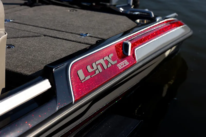 Slide: The Image of 2026 Bass Cat Lynx STS boat with red detailing on the deck. - 2