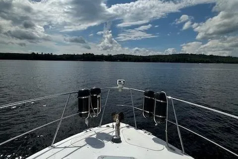 Slide: The Image of Bow view of 2001 Carver 350 Mariner on a serene lake under a partly cloudy sky. - 15