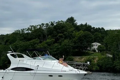 Slide: The Image of 2001 Carver 350 Mariner yacht cruising on a lake with lush green trees in the background. - 8