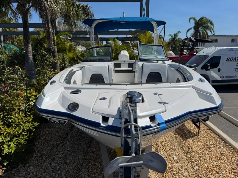 Slide: The Image of 2020 Monterey M-65 boat with blue canopy, parked outdoors near palm trees. - 17