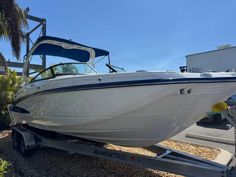 Slide: The Image of 2020 Monterey M-65 boat on trailer with blue canopy, parked outdoors. - 18