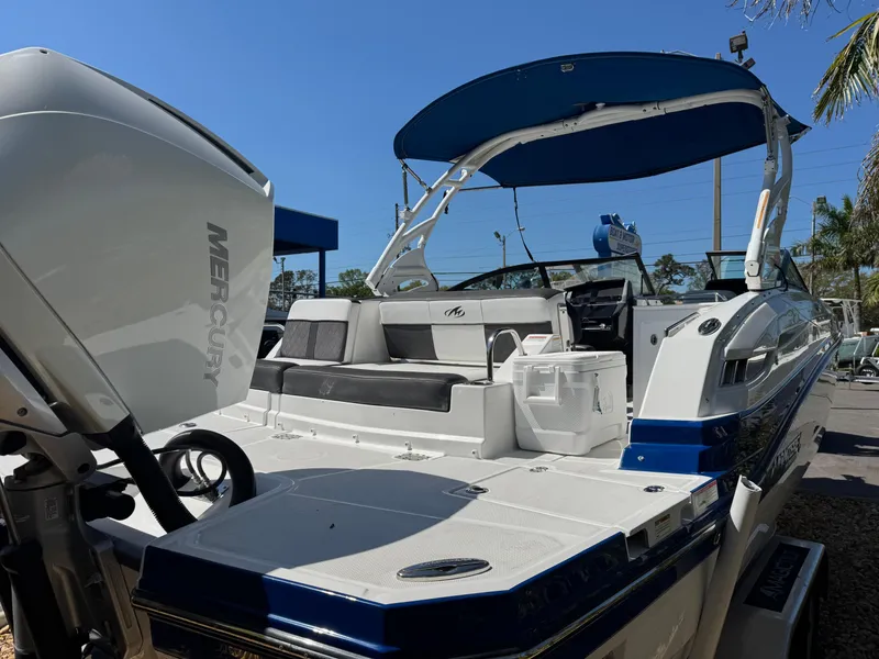 Slide: The Image of 2020 Monterey M-65 boat with blue canopy and Mercury engine, docked under clear sky. - 21