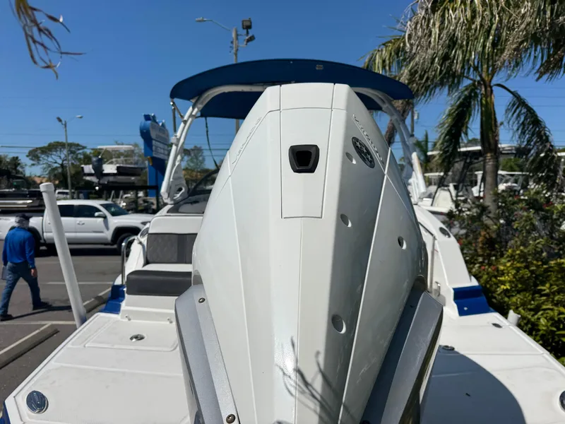 Slide: The Image of 2020 Monterey M-65 boat, docked, with palm trees and vehicles in the background. - 22