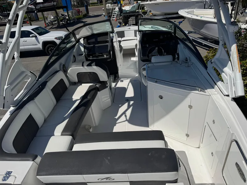 Slide: The Image of 2020 Monterey M-65 boat interior with seating and helm, docked outdoors. - 28