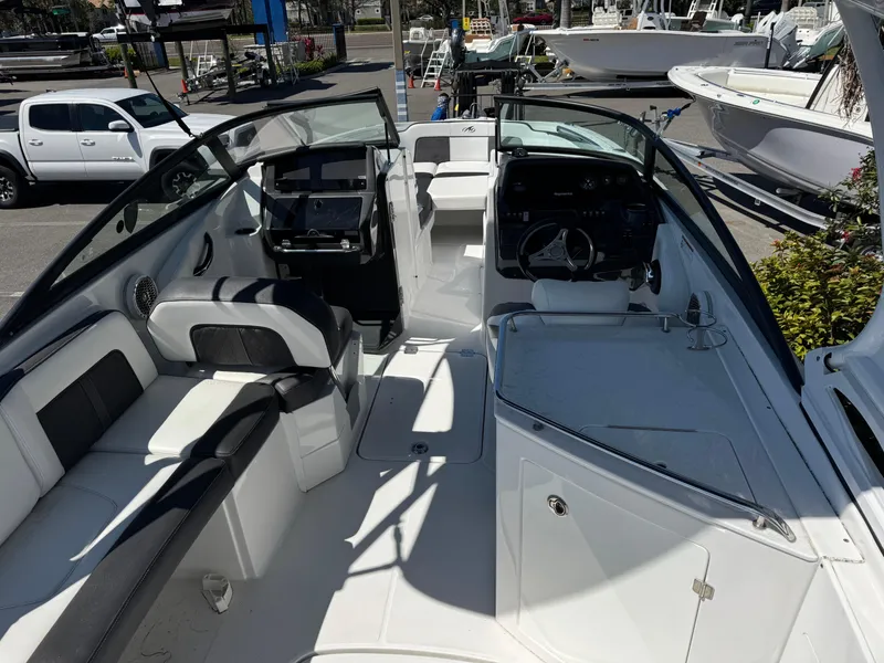 Slide: The Image of 2020 Monterey M-65 boat interior with seating and control panel, parked in a marina. - 29