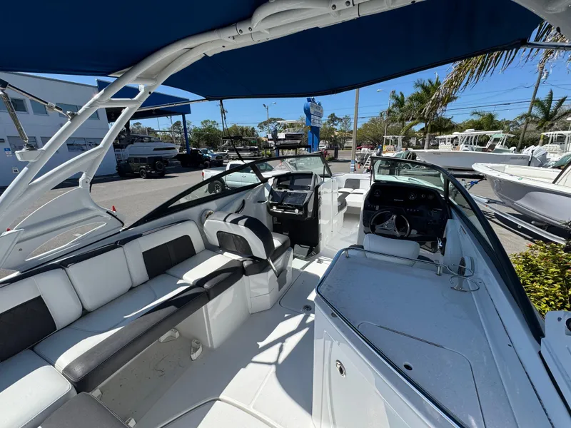 Slide: The Image of 2020 Monterey M-65 boat interior with seating and helm, under blue canopy. - 31