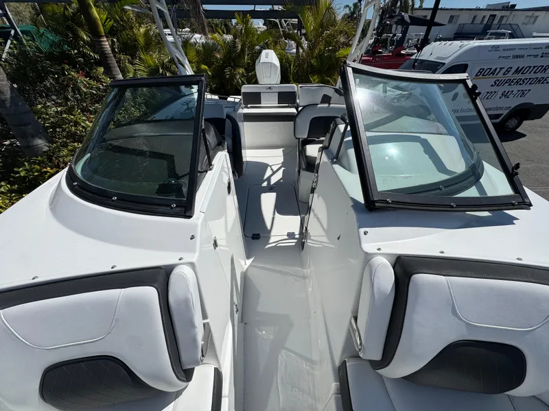 Slide: The Image of 2020 Monterey M-65 boat interior with open seating and windshield, docked outdoors. - 41
