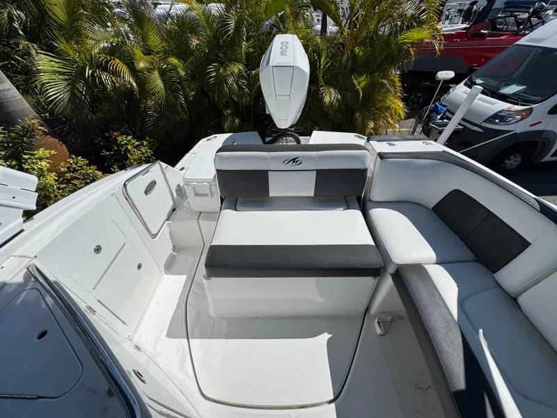 Slide: The Image of 2020 Monterey M-65 boat interior with white seating and lush greenery background. - 46