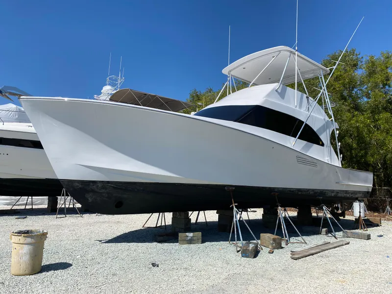 Slide: The Image of 2017 Tides 45 Sportfish boat on stands, white hull, clear sky background. - 0
