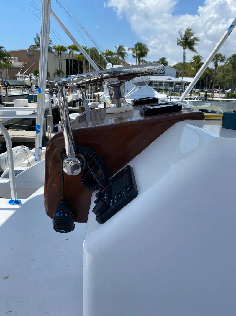 Slide: The Image of 2017 Tides 45 Sportfish helm with controls and microphone, docked under a sunny sky. - 20