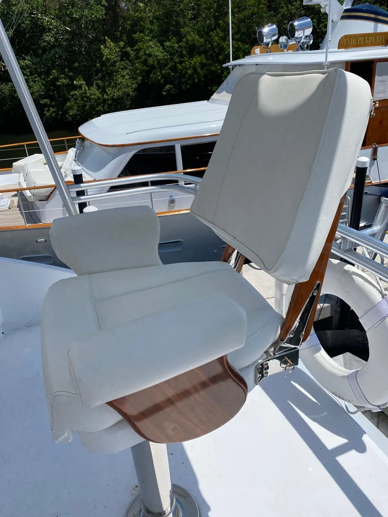 Slide: The Image of Captain's chair on 2017 Tides 45 Sportfish yacht, featuring white upholstery and wooden accents. - 21