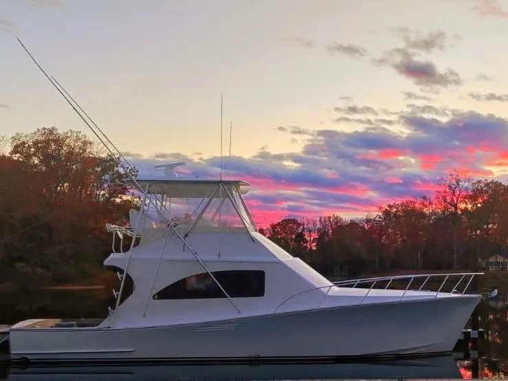 Slide: The Image of Tides 45 Sportfish 2017 yacht at sunset with vibrant sky and calm water. - 23